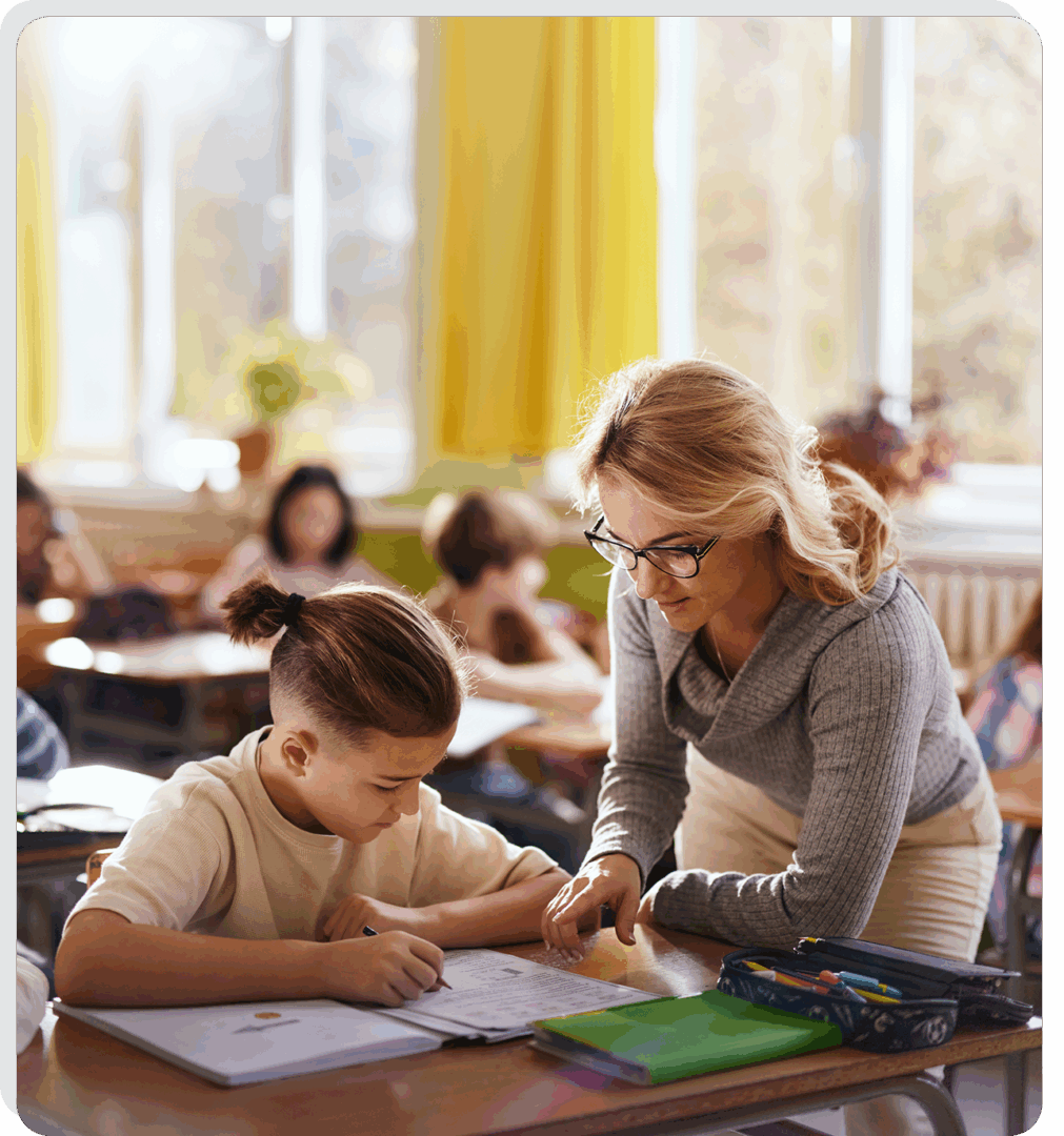 Teacher helping student in a classroom setting.