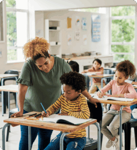 Teacher assisting student in a classroom setting.