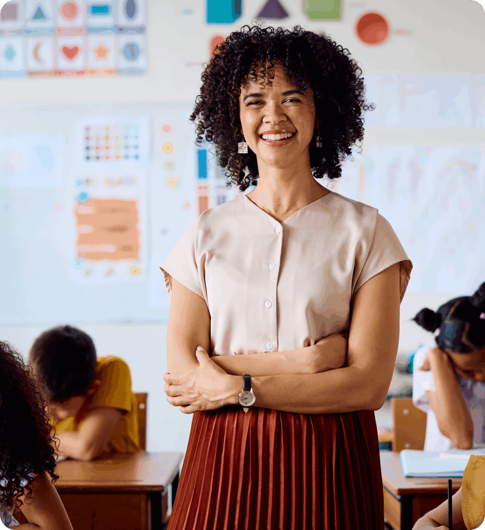 Smiling teacher standing in a classroom.